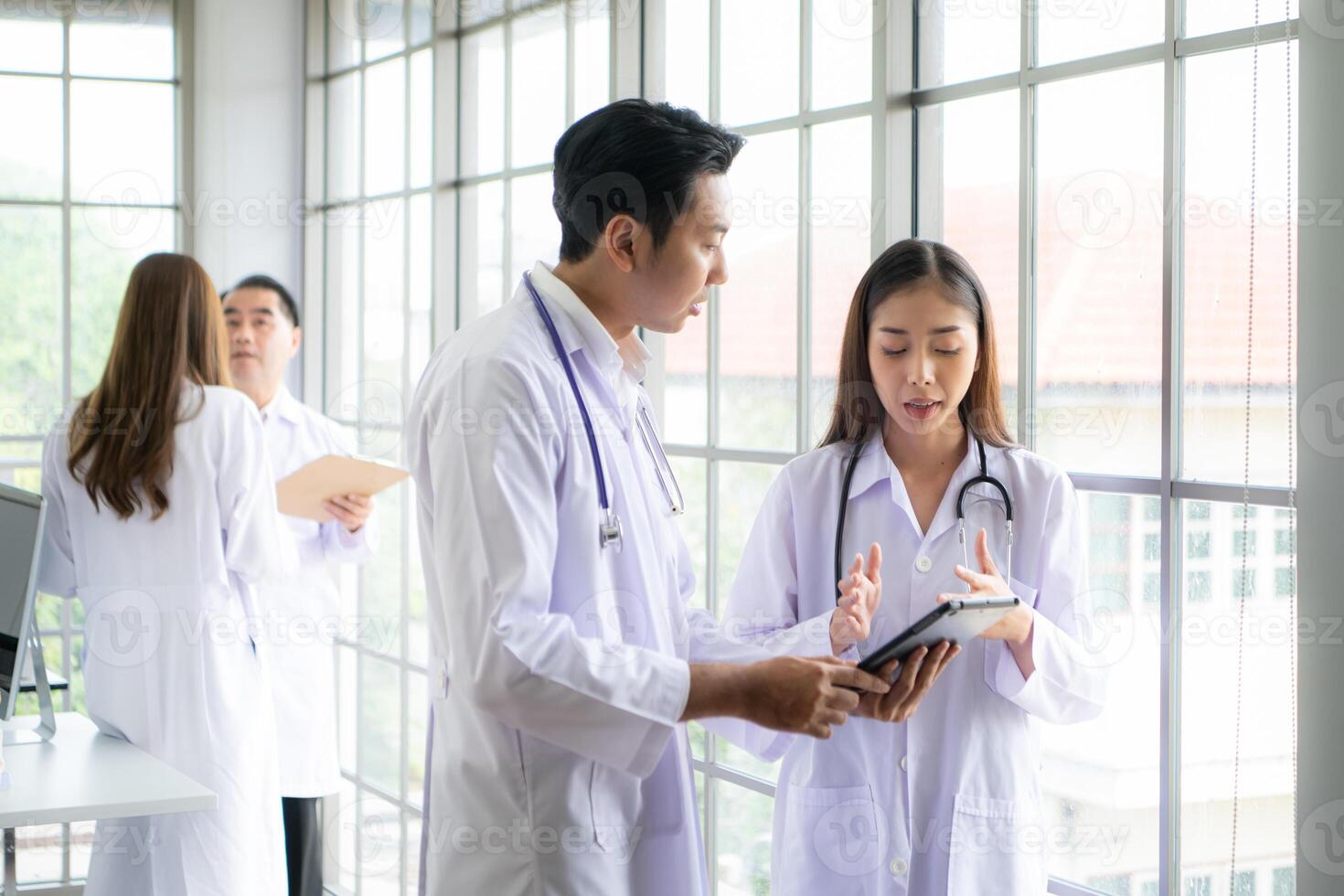 A team of medical discuss a case study involving disease therapy for a hospital patient. photo