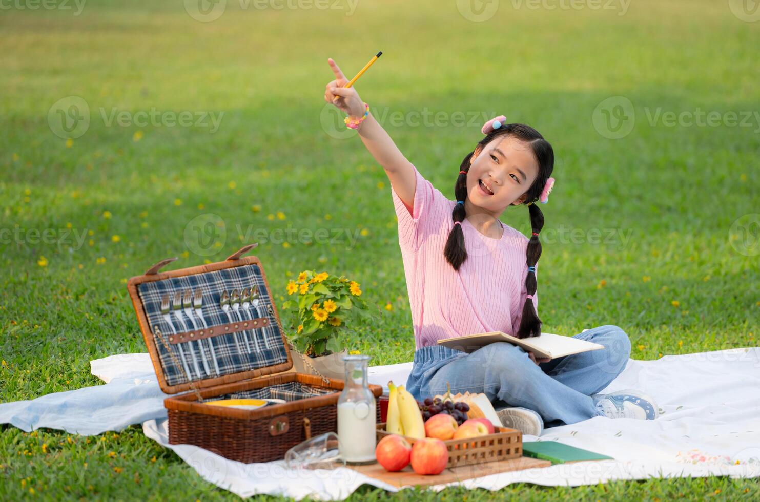 Happy family enjoying a picnic in the park, Girl sitting and reading books. photo