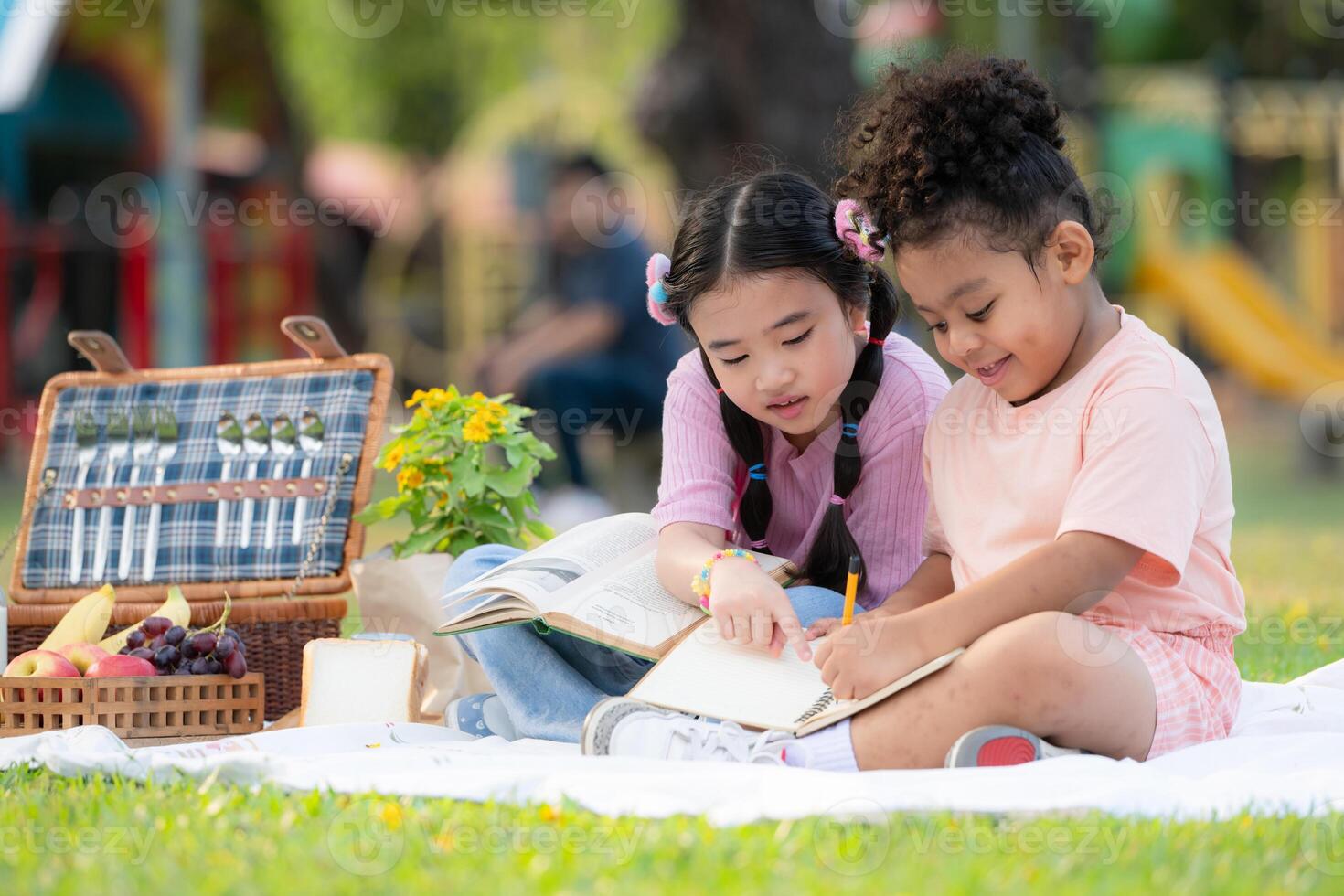 Happy family enjoying a picnic in the park, Children are having fun drawing on paper. photo