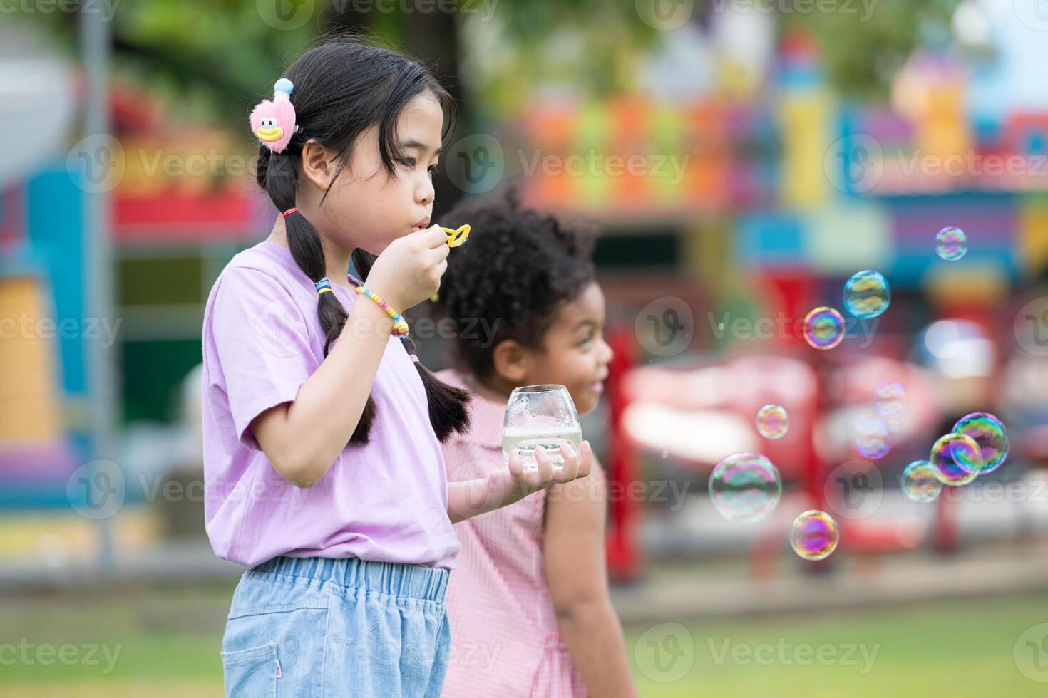 Girls in the park with blowing air bubble, Surrounded by greenery and nature photo