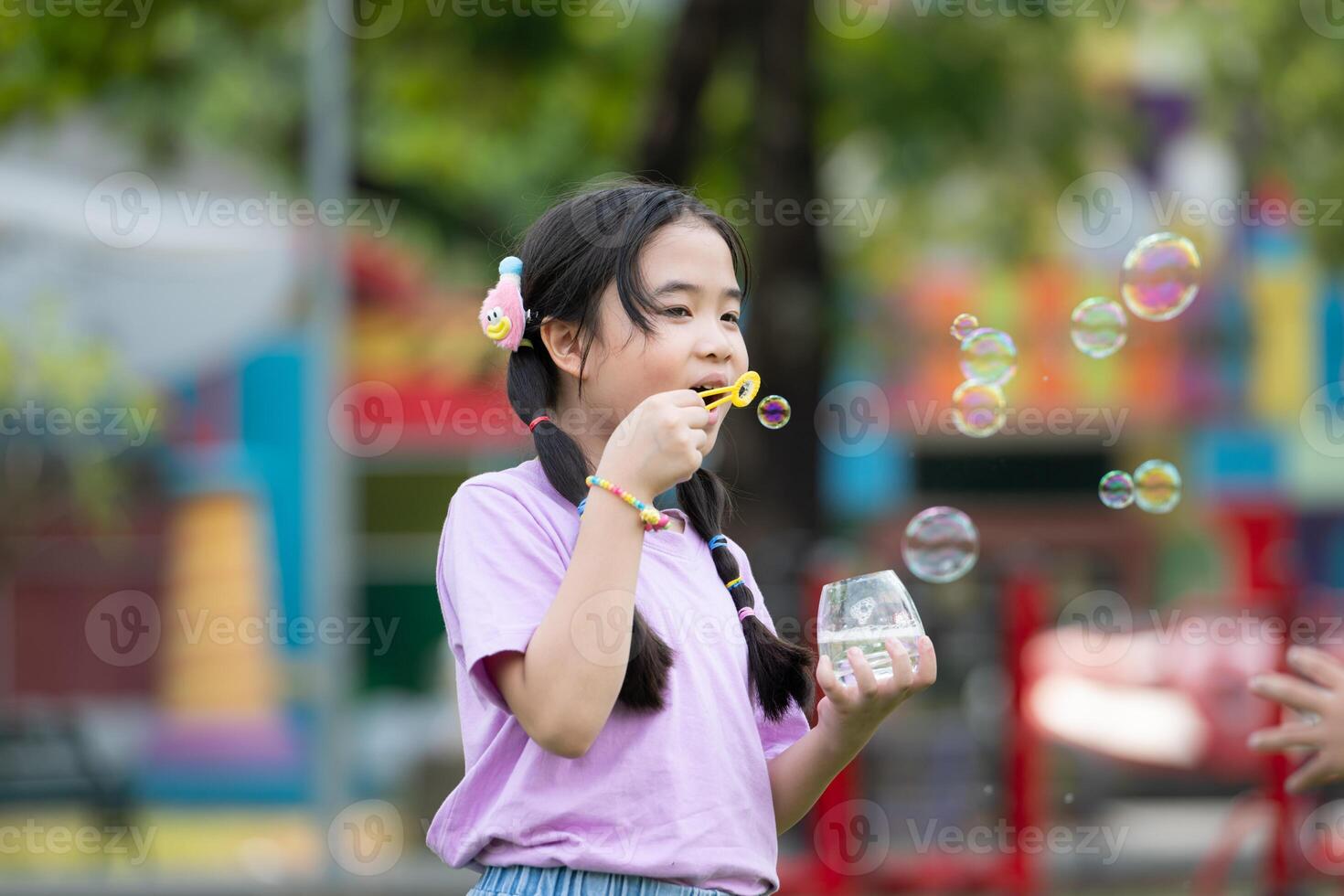 Girls in the park with blowing air bubble, Surrounded by greenery and nature photo
