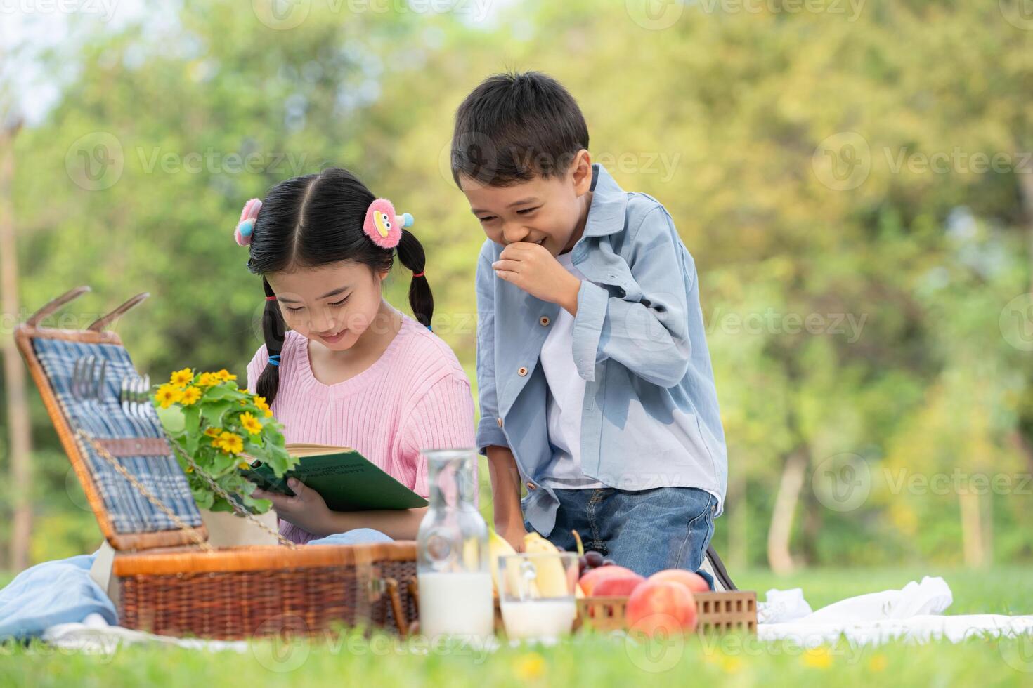 contento familia disfrutando un picnic en el parque, niños sentado espalda a espalda y leyendo libros. foto