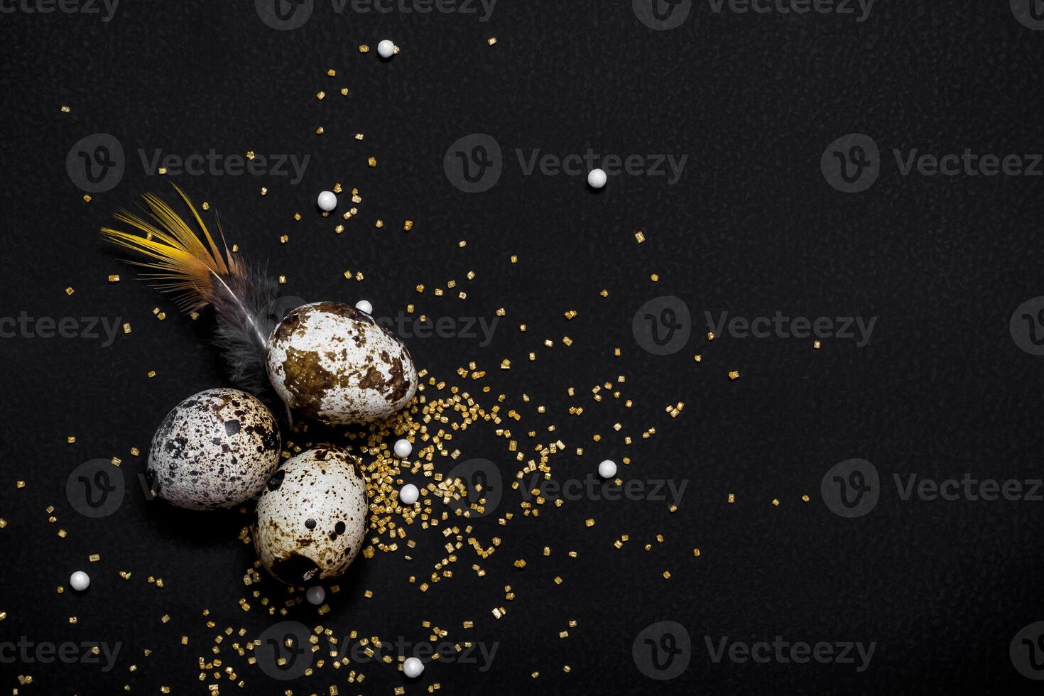 Moody easter decor. Quail eggs and feathers on black background. Happy easter holiday photo