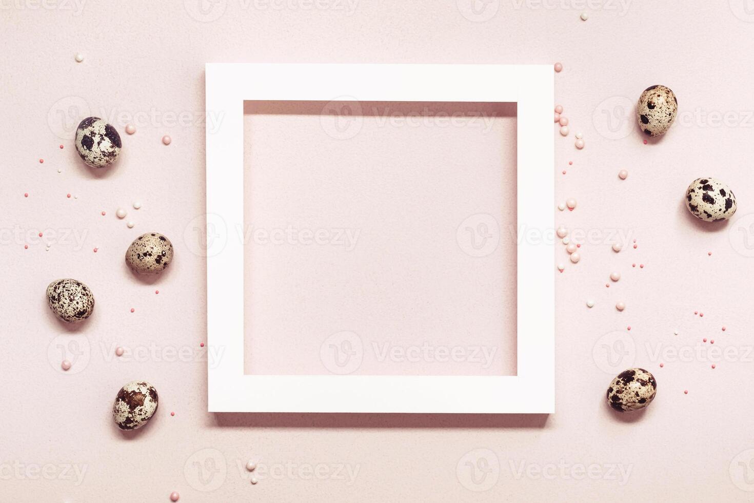 White Frame and quail eggs over pink pastel background. Happy easter minimal concept photo