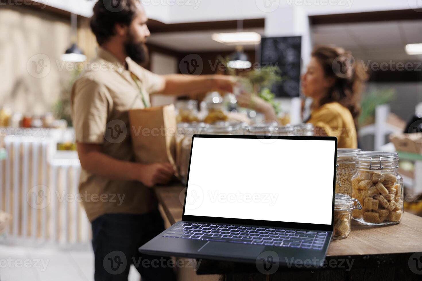 Vendor showcasing chemicals free products in marketplace venue, using mockup laptop to advertise business. Farmer trading organic food during local event using empty copy space on device for promotion photo