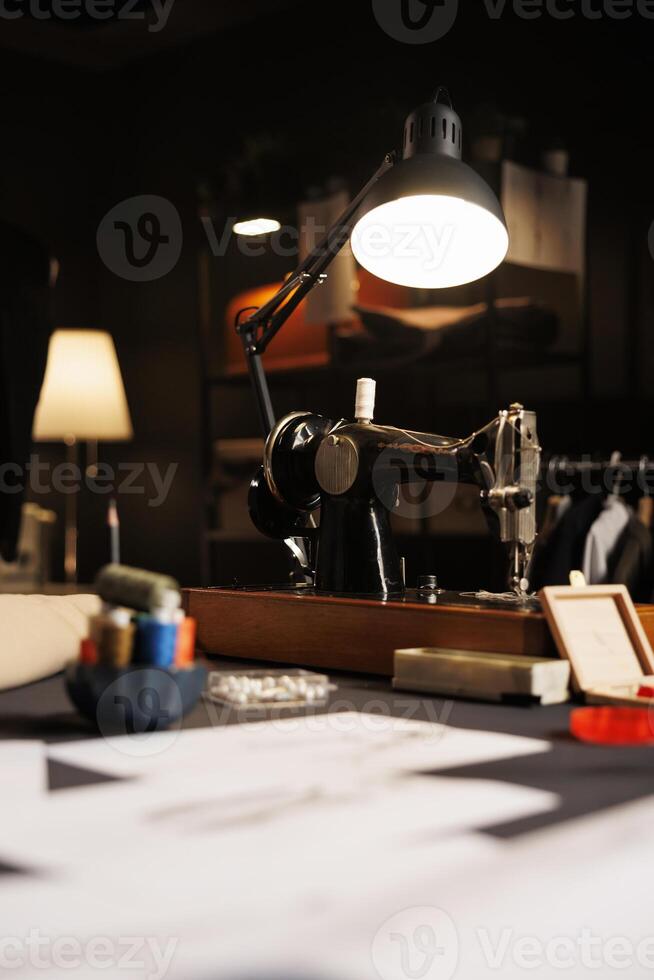 Focus on industrial sewing machine in tailoring studio used for cutting textile materials and embroidery. Professional premium atelier shop workspace filled with dressmaking instruments photo