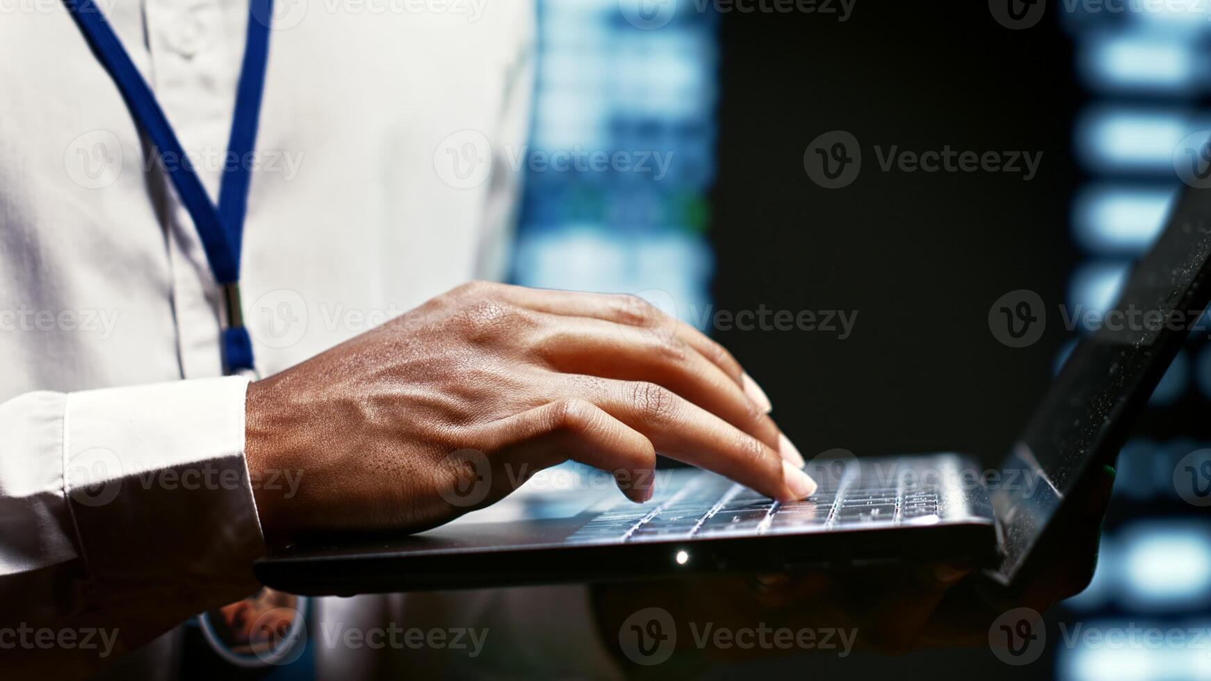 IT developer using laptop to examine server mainframes providing vast computing resources and storage, enabling artificial intelligence to process massive datasets for training and inference, close up photo
