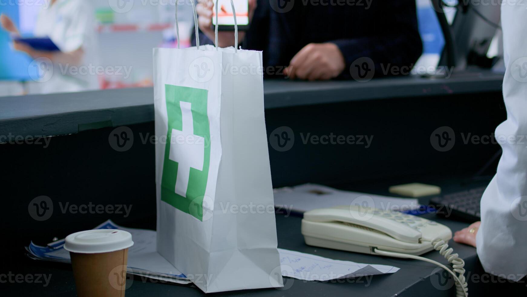 Client at pharmacy counter, showing employee prescribed cardiovascular pills picture on smartphone, ready to buy it. Pharmacist assisting customer with required medication pills, close up photo