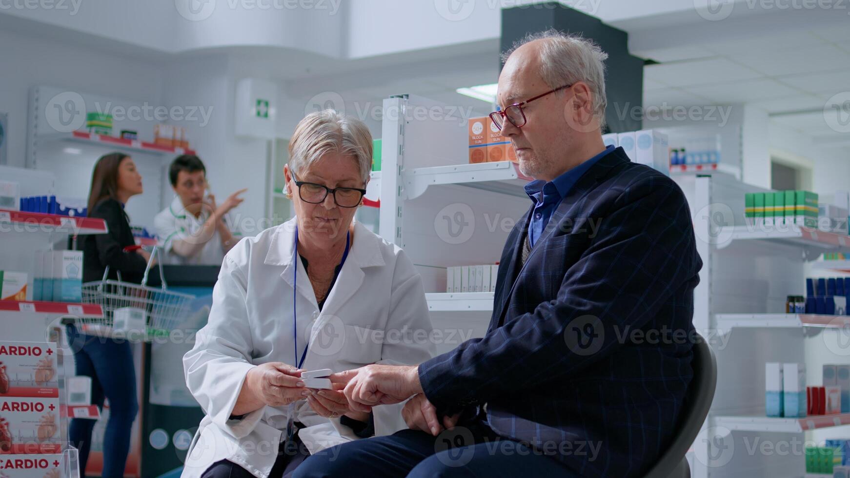 Elderly pharmacist clipping senior patient finger using pulse oximeter, monitoring level of blood oxygen saturation and heart rate during annual examination in pharmacy offering full range of services photo