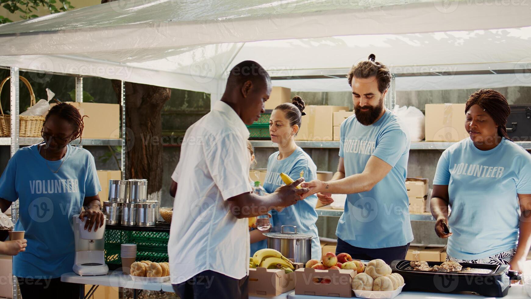 Multicultural hunger relief team distributes free meals to the hungry while also assisting and supporting the homeless. Volunteers distributing hot meals in an effort to reduce hunger and poverty. photo