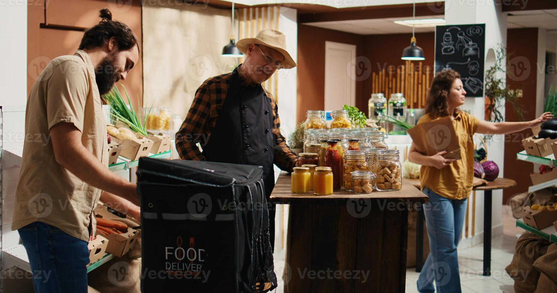 Deliveryman arriving in eco friendly supermarket to pick up organic food order for customer. Man delivering farm grown fruits from local neighborhood shop, receiving groceries from elderly vendor photo