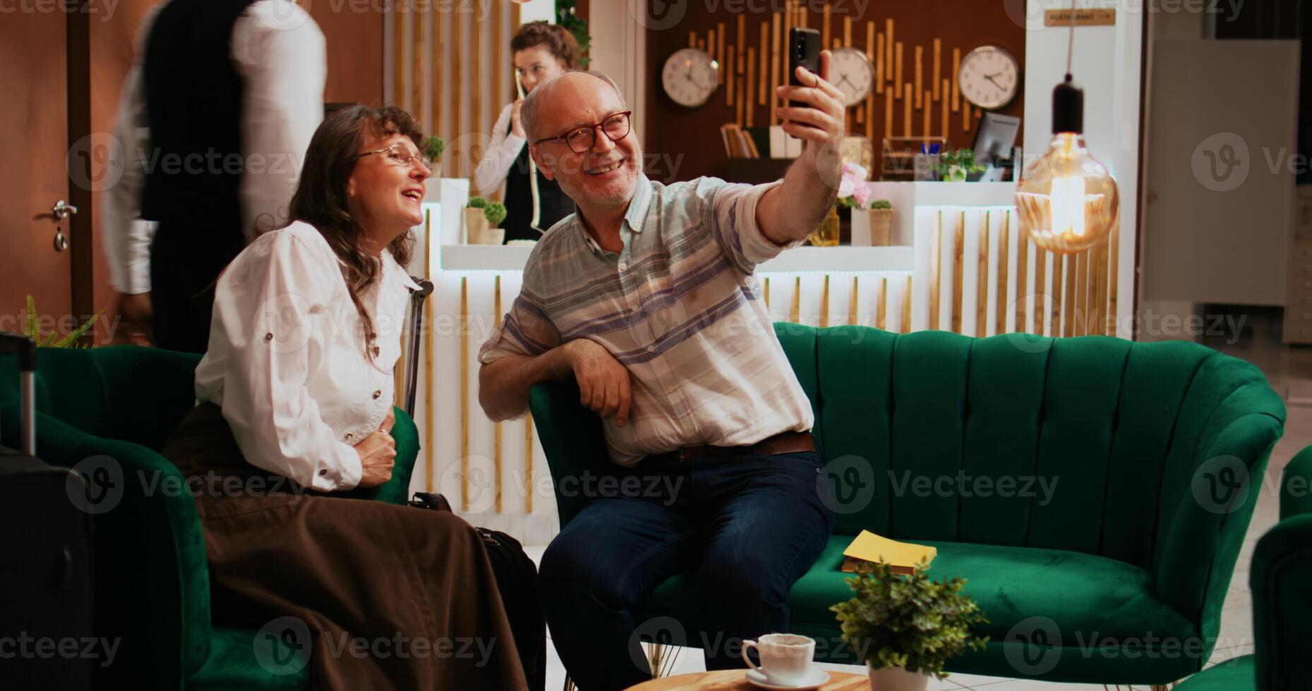 Older guests using videocall connection to keep in touch with family back home, travelling on retirement holiday. Husband and wife talking to children and nephews on teleconference call. photo