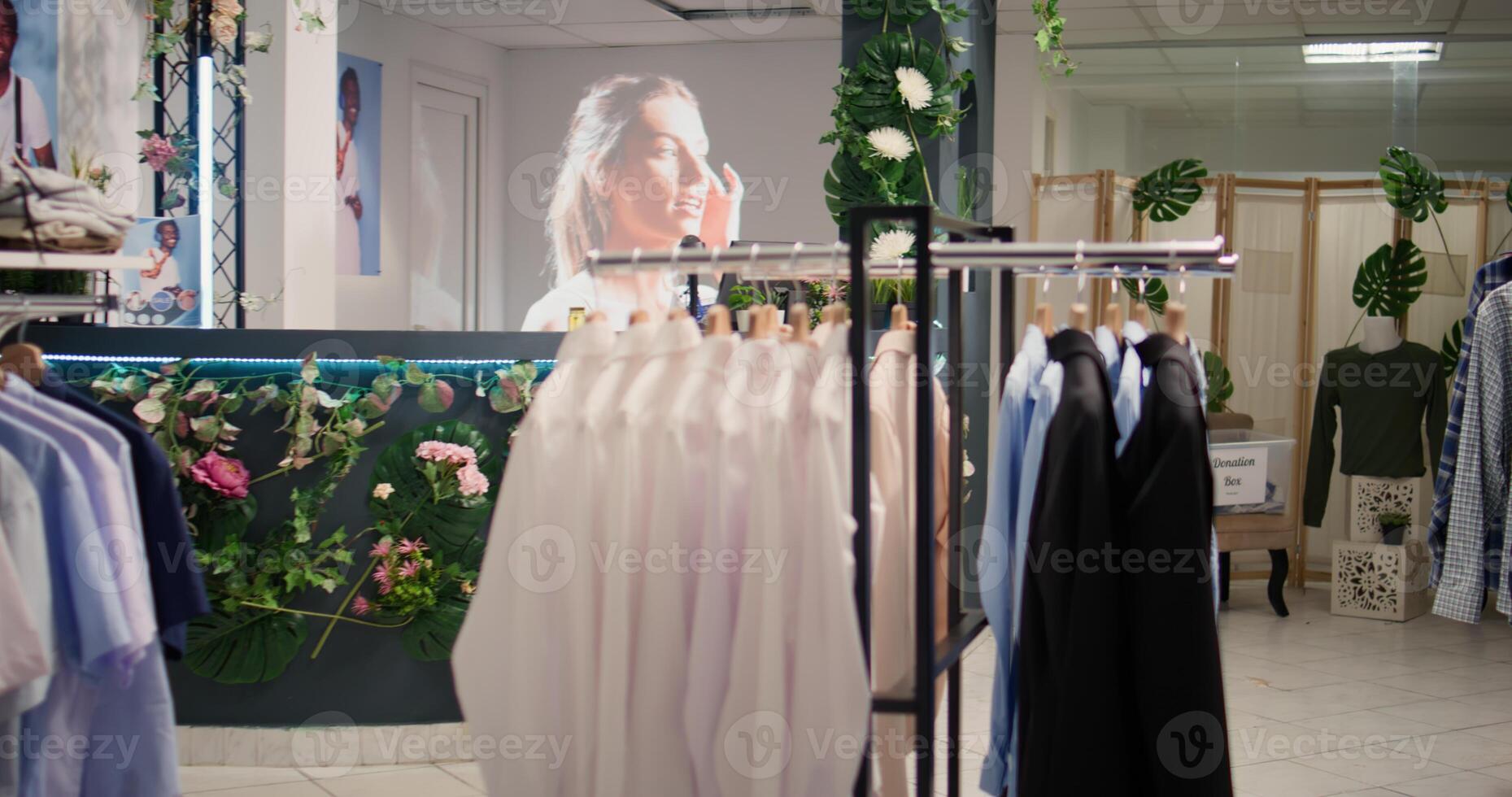 Dolly out shot of wares in thrift shop with vintage clothes on racks. Professional interior design in empty premium second hand clothing store selling old high street garments photo