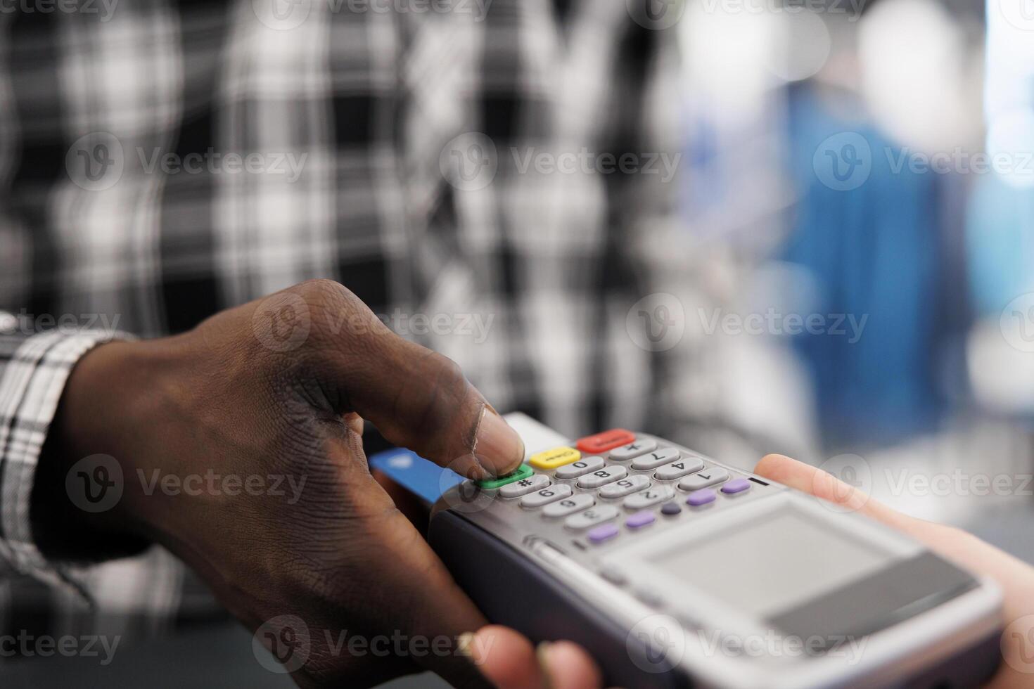 African american client introducing credit card detalis on pos to pay for stylish clothes, making contactless payment. Shopaholic man buying fashionable items for formal wear in boutique. Close up photo