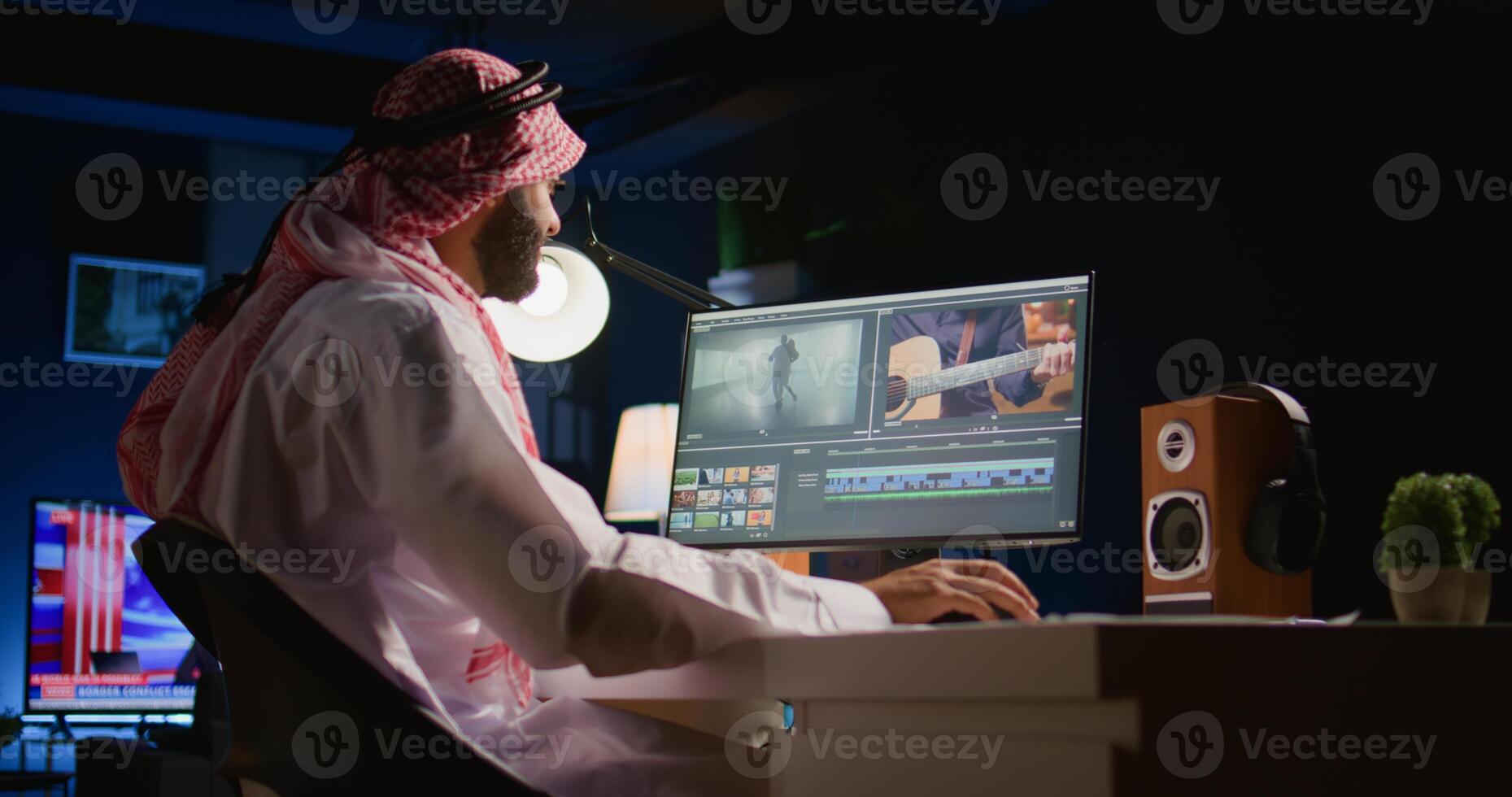 Arabic colorist freelancer wearing headphones while editing project, stitching videos together, working with images and sounds. Self employed man processing movie on PC workstation photo