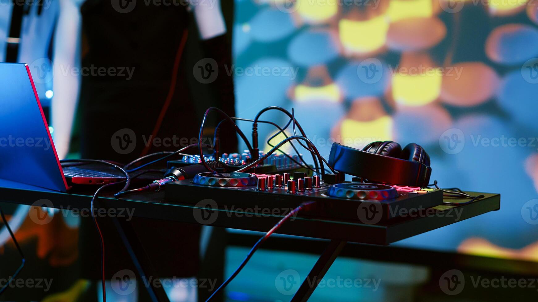 Empty DJ mixing panel at funky club, spotlights and disco ball at the bar used for dancing and clubbing. Dance floor at discotheque with audio equipment station used for partying, nightlife. photo