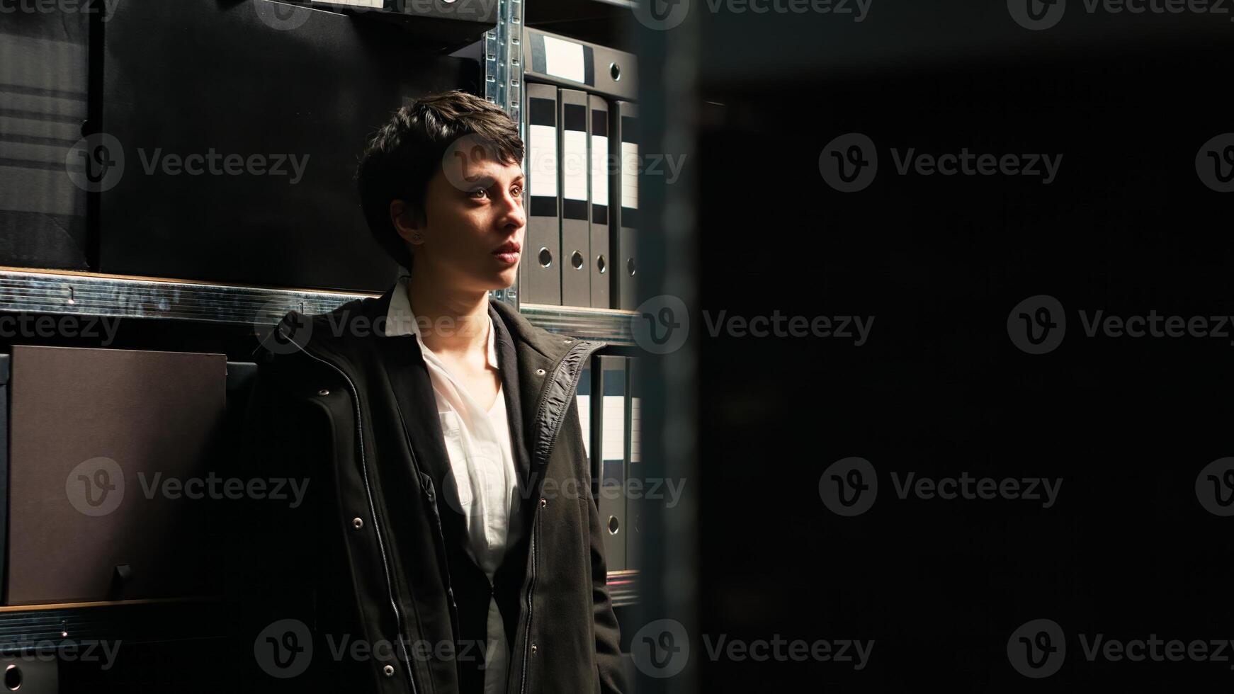 Private detective handling investigation with clues and case files, working on criminal evidence discovery in police agency. Woman law officer in incident room, clandestine operation. photo