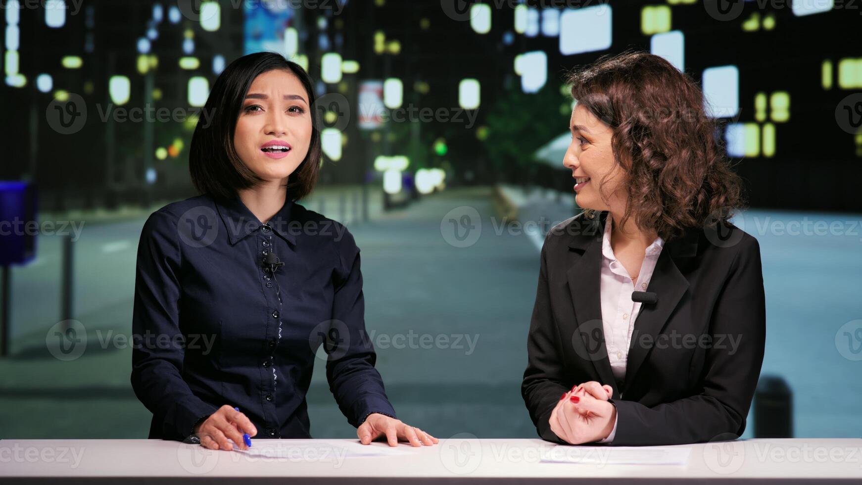 Newscasters team hosting night show in newsroom, talking about latest events in daily reportage live on television program. Media reporters presenting news report during talk show at midnight. photo