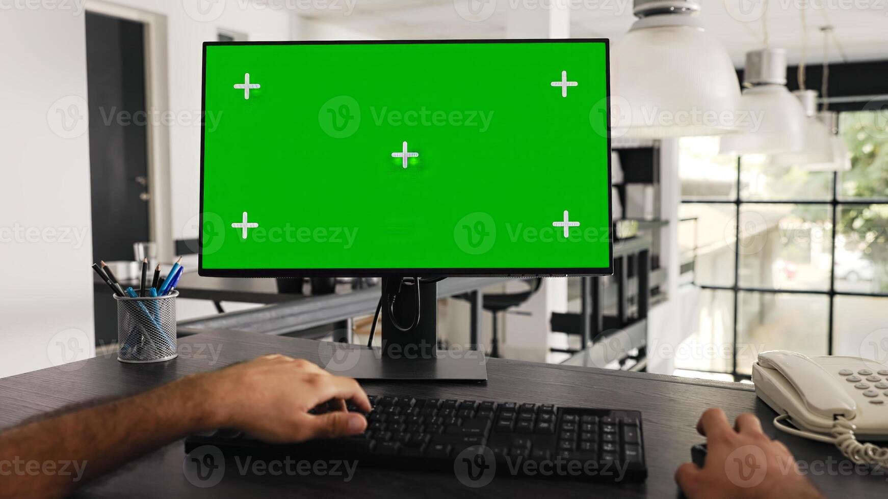 POV of businessman works at greenscreen pc in front of computer, solving daily tasks and looking at monitor running blank chromakey template at workstation. Worker uses mockup screen. Tripod shot. photo