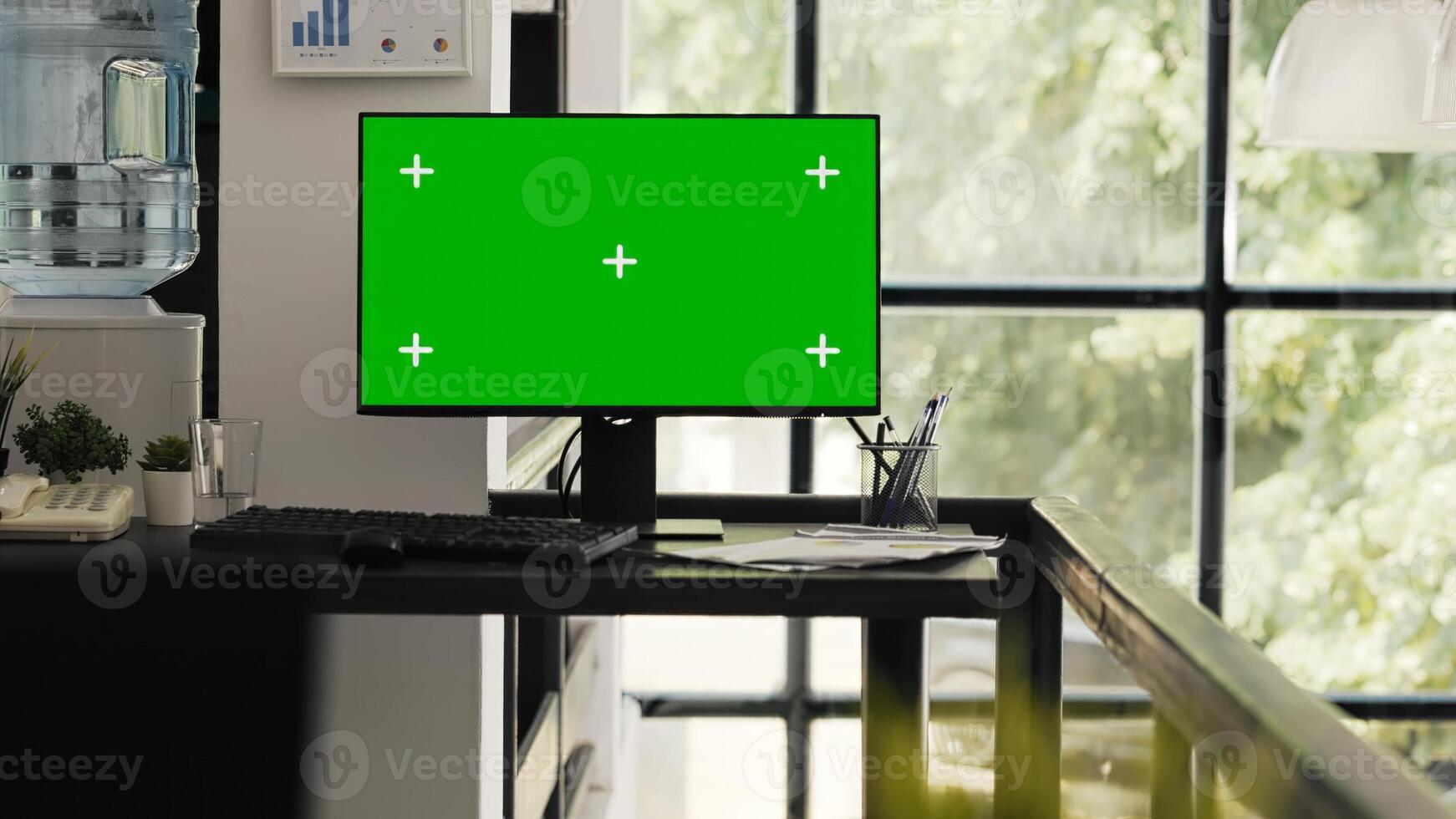 Empty office with greenscreen desktop showing isolated copyspace layout in open floor plan coworking space. Workstation desk with computer monitor presenting blank mockup screen. photo