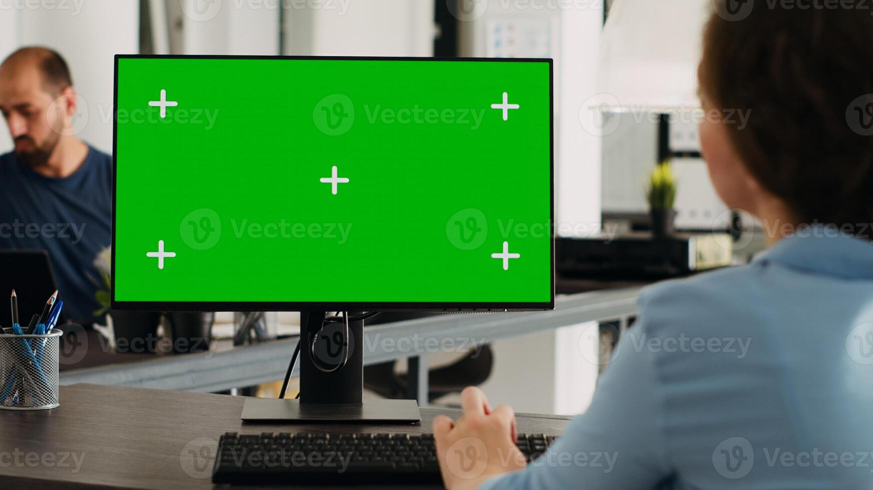 Manager working with isolated greenscreen on computer at workstation, looking at chromakey display with mockup template on desk. Businesswoman using pc in coworking space. photo