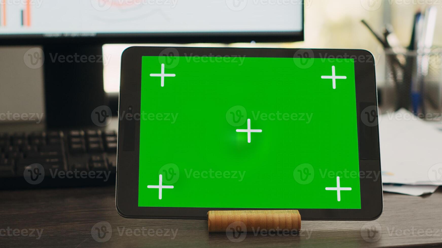 Empty desk with greenscreen on tablet in business coworking space, isolated copyspace layout on modern gadget display. Workstation with device showing chromakey mockup screen. photo