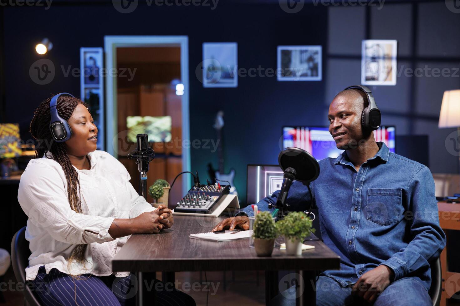 During this talk show, a male host interviews with a female influencer using a professional microphone. Together, they create engaging creative content for their online audience. photo
