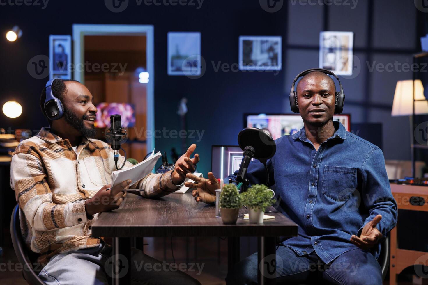 Live talk show is hosted by a dynamic duo discussing various topics and interacting with fans. Black men using professional microphones to produce high quality content for online streaming service. photo