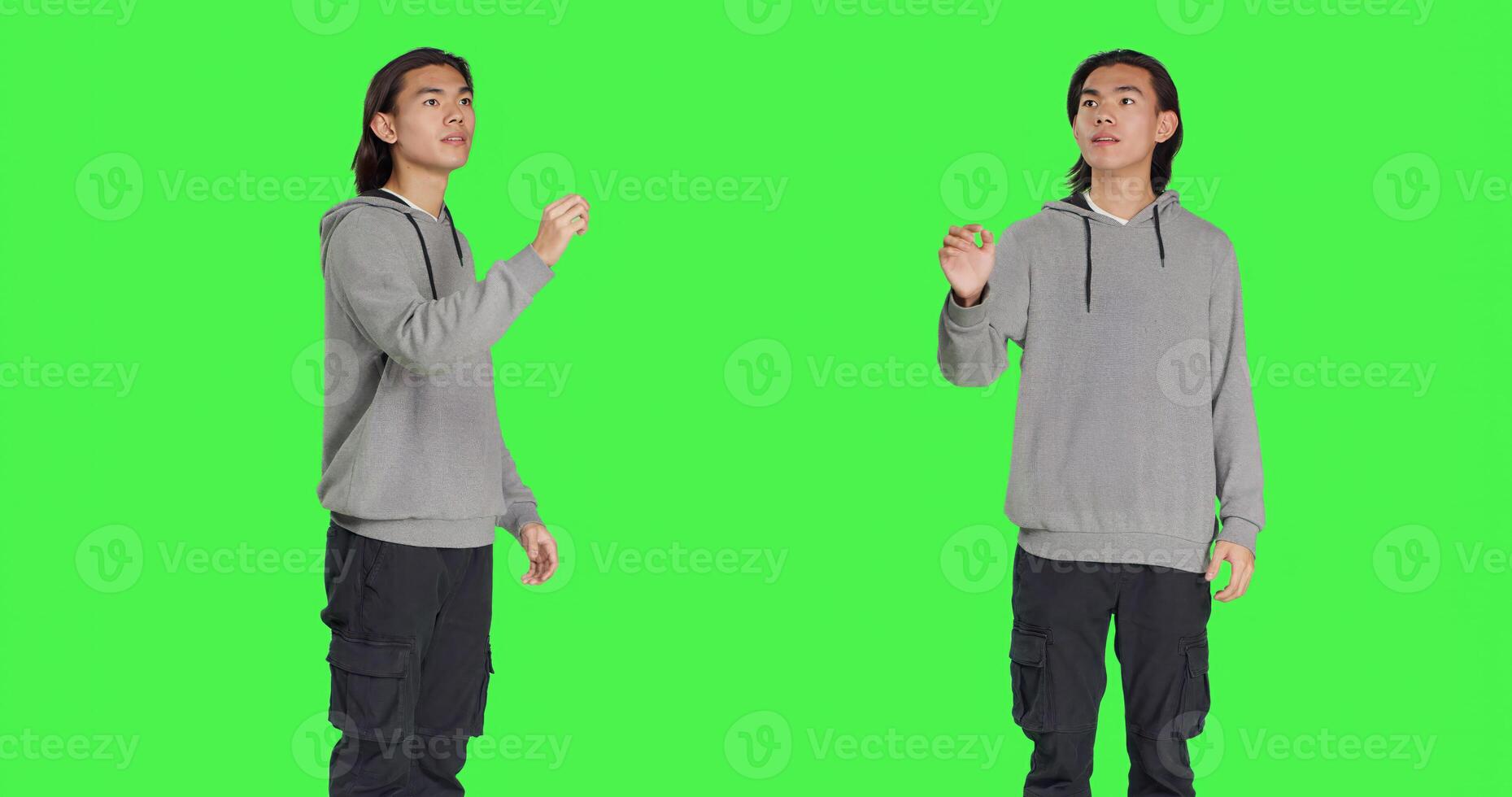Young adult checking hologram icon in studio with greenscreen backdrop, looking at modern holographic image and focusing on work. Asian casual guy using artificial intelligence. photo