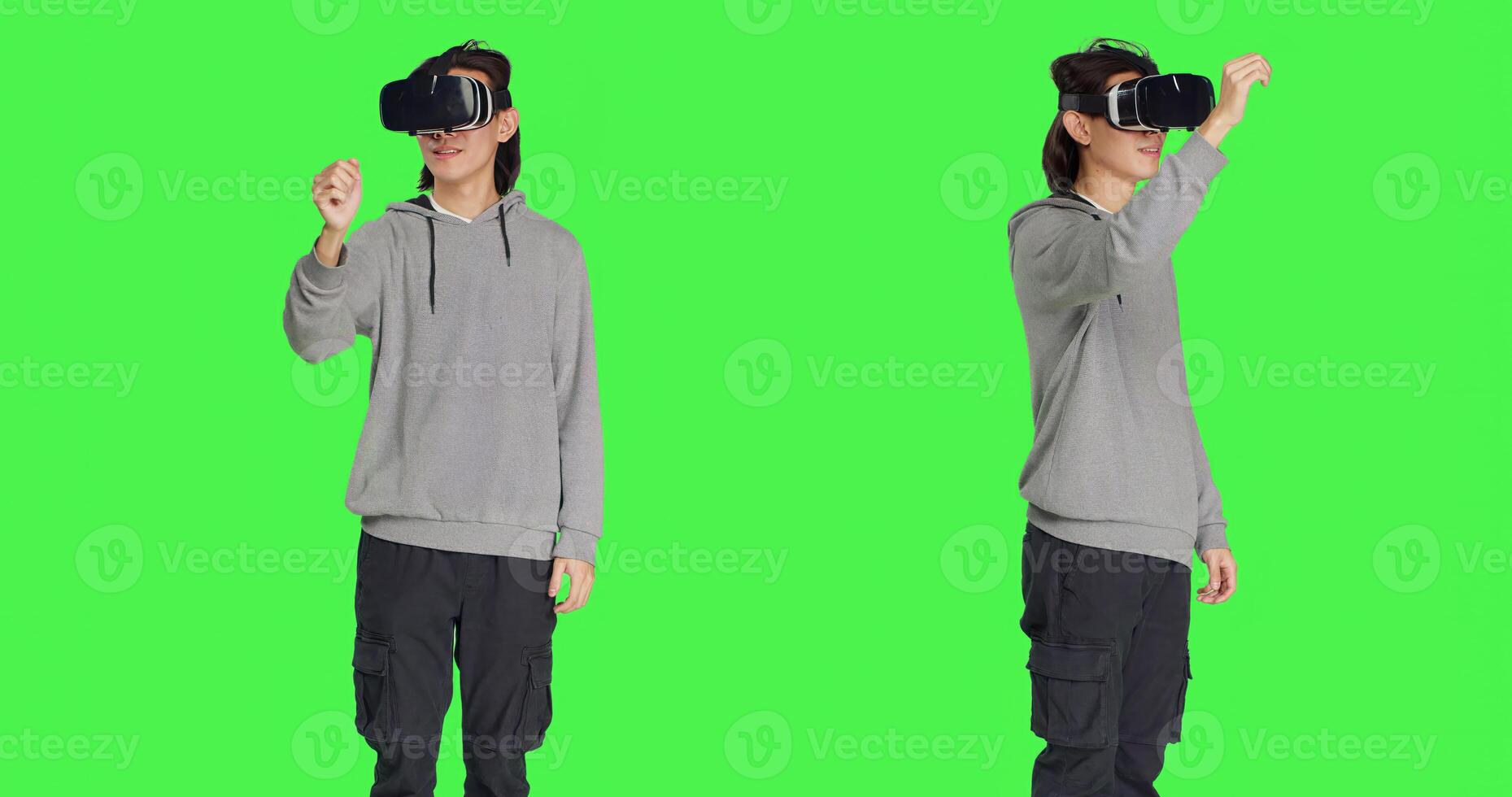 Male person using virtual reality gadget in studio with greenscreen backdrop, having fun with interactive 3d headset. Modern asian man enjoying artificial intelligence vr glasses. photo