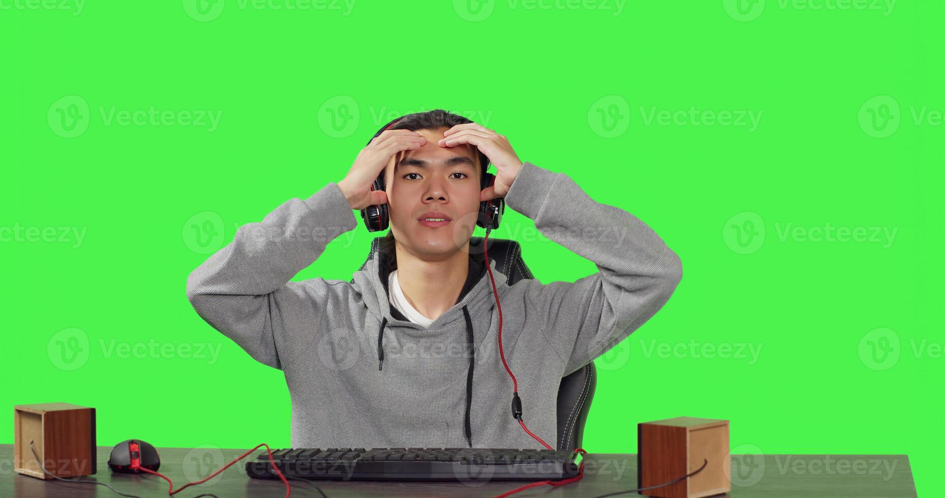POV of gamer plays pc games at workstation, sitting on chair over greenscreen background. Online player having fun with people on rpg gaming competition, wearing headset at his desk. photo