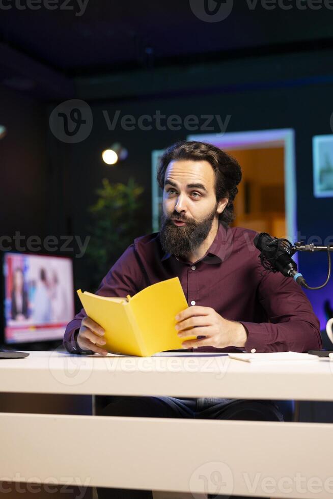 Online show host being sponsored by partnering publisher to do new book presentation. Content creator does influencer marketing, doing new author novel product placement in studio photo