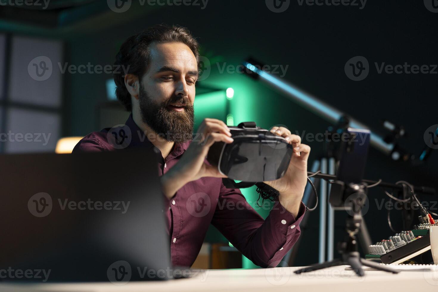 Tech expert assessing VR goggles performance, talking about components used inside, doing unboxing video. Entertainer unpacking virtual reality headset to review it on technology online channel photo