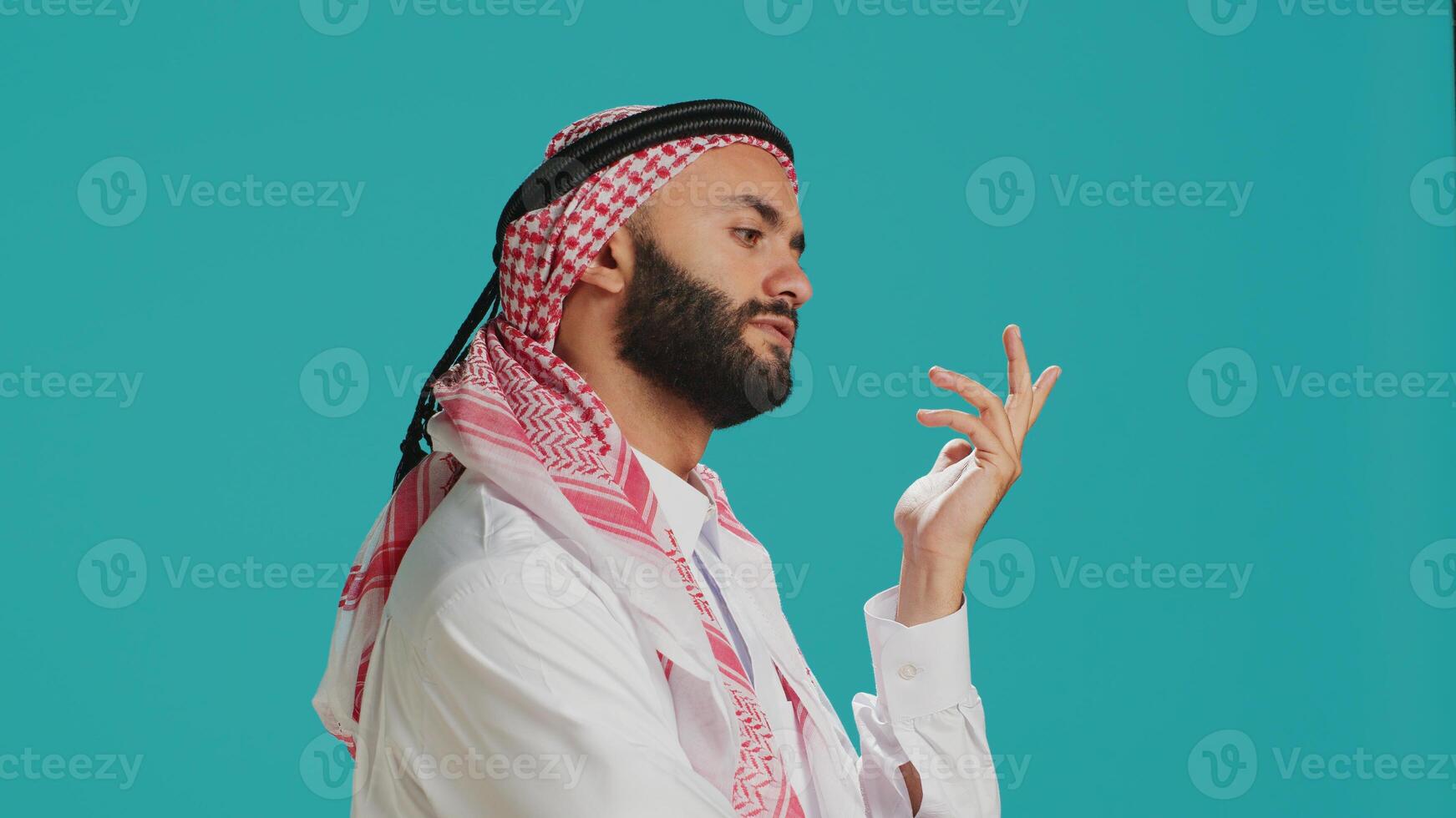 Middle eastern man being puzzled and thinking about solution, being interested about a subject and trying to find answer. Young adult being pensive in studio, wondering about new idea. photo