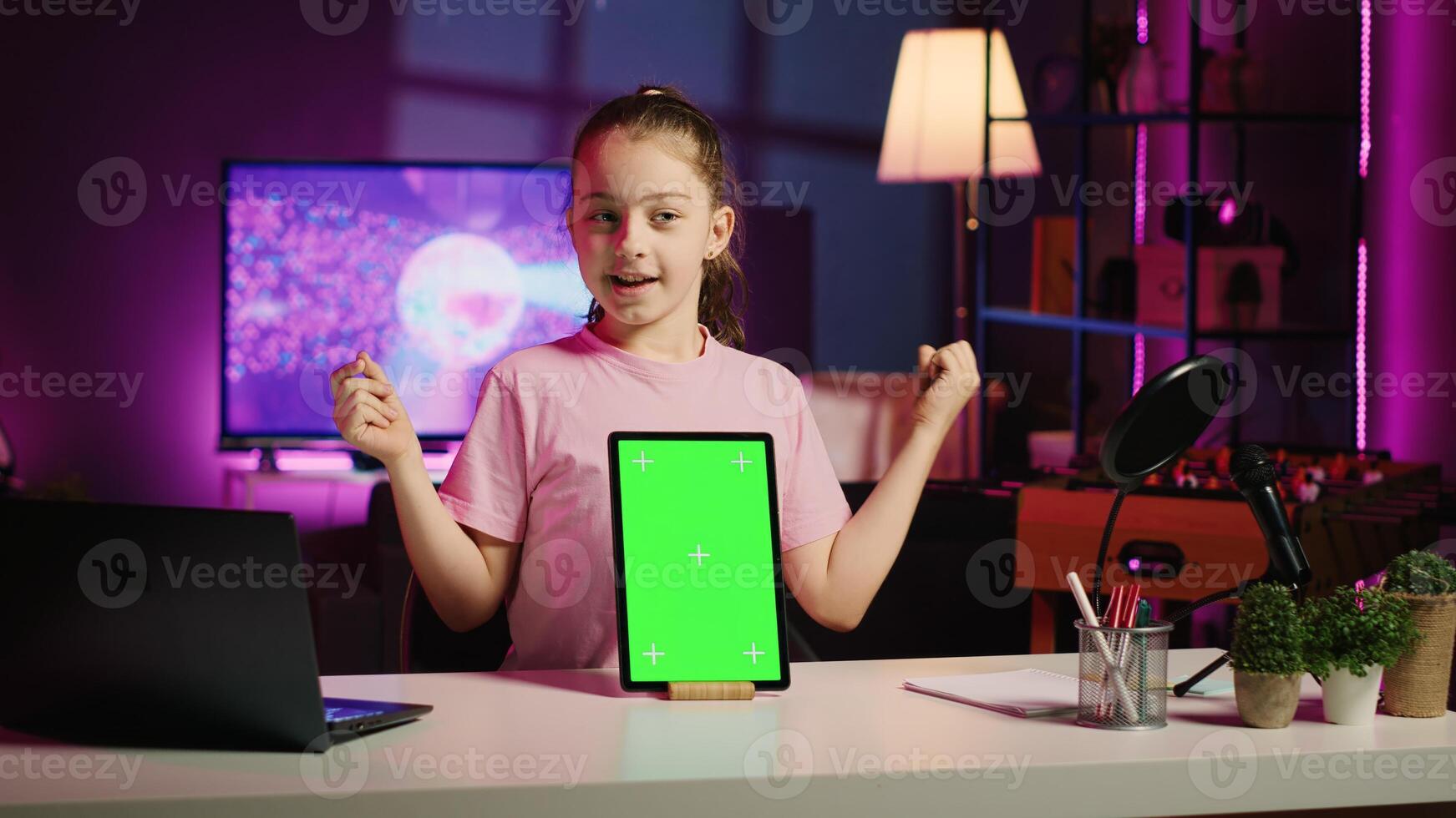 Children internet show host promoting green screen tablet received from sponsoring brand. Young kid star does influencer marketing, urging followers to purchase chroma key device photo
