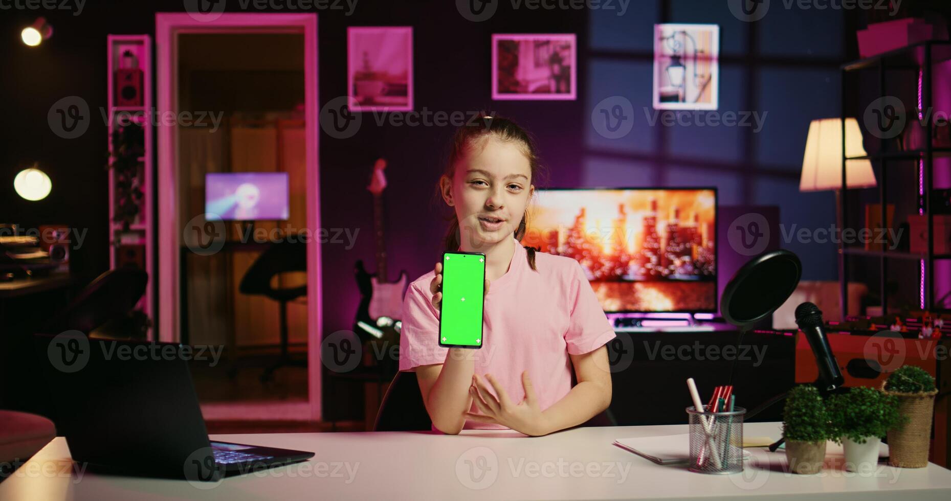 Cute kid filming internet show, promoting green screen tablet received from sponsoring brand. Little girl does influencer marketing, urging followers to purchase chroma key device photo