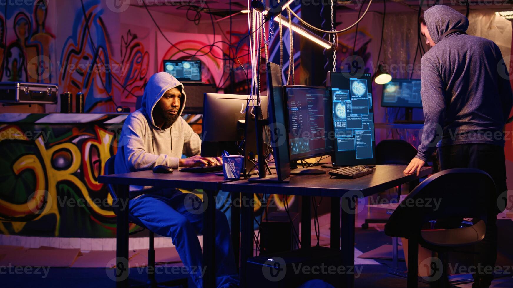 Hackers in secret base talking about technical knowhow details before using bugs and exploits to break into computer systems and access valuable data, bypassing firewalls, zoom out shot photo