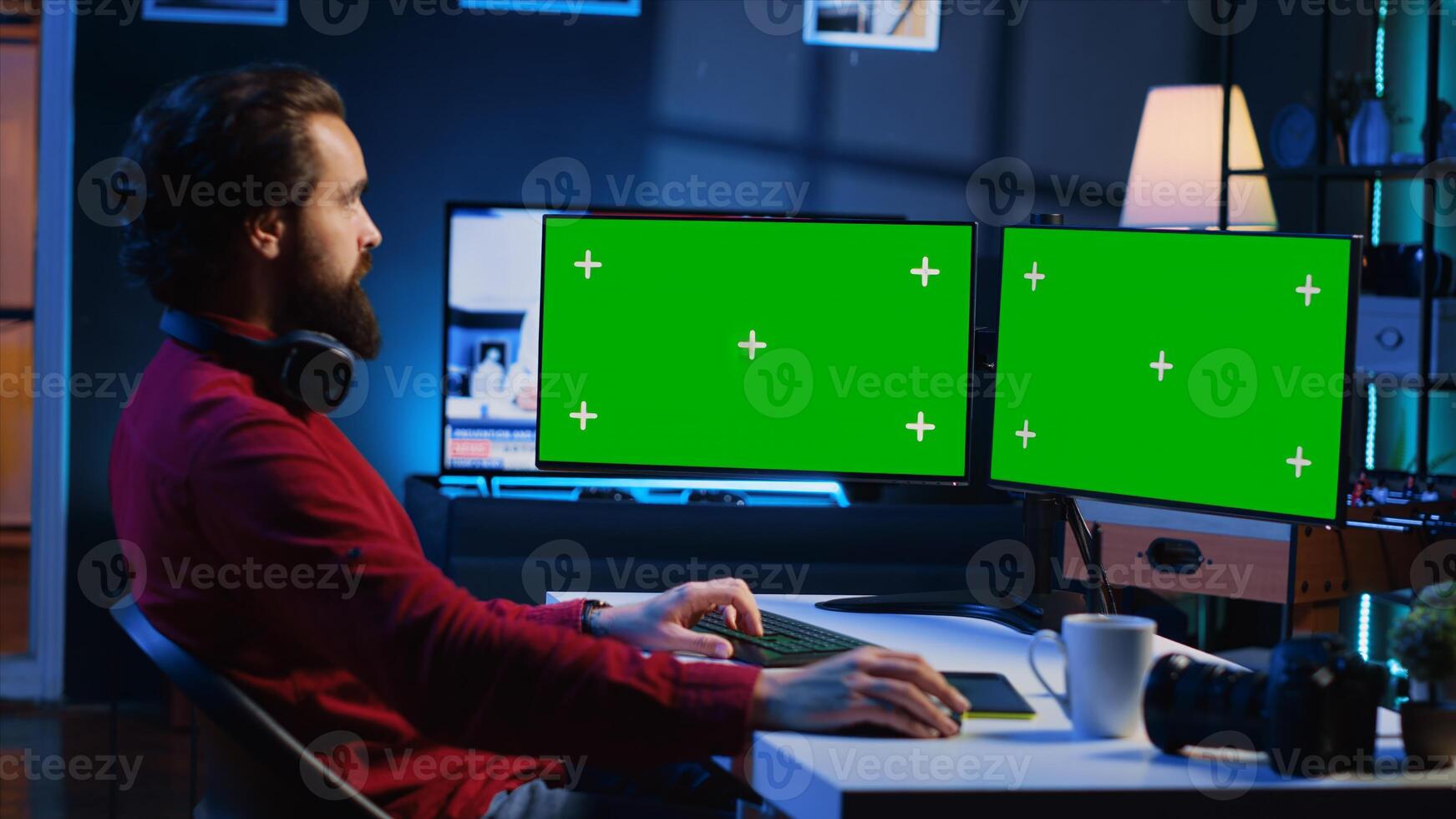 Photo editor using green screen monitor to color correct photographs in creative studio. Photographer selecting best pictures for editorial content with chroma key desktop computer