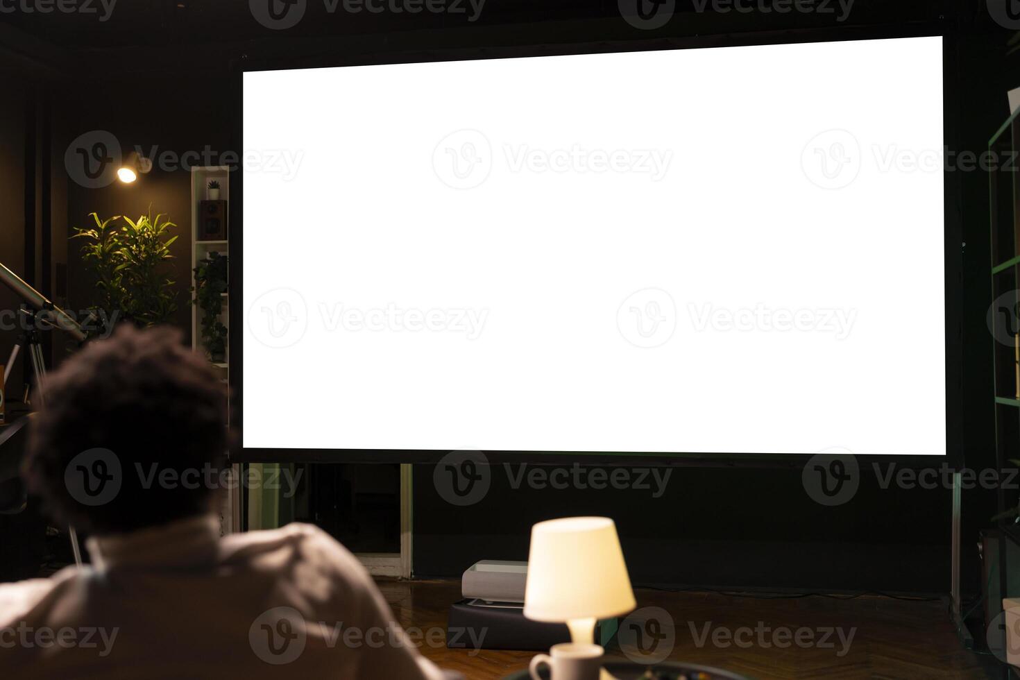 Person using isolated screen large smart TV to binge series on subscription based streaming services, having fun. BIPOC man relaxing, enjoying VOD shows on mockup television display photo