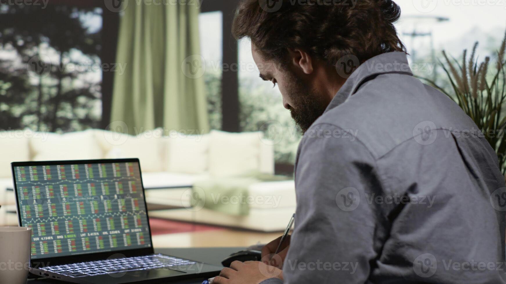 From his exquisite sophisticated real estate in the mountains, banker opens laptop to track earnings developments and monitors global trends. Independent contractor relaxing at his holiday property. photo
