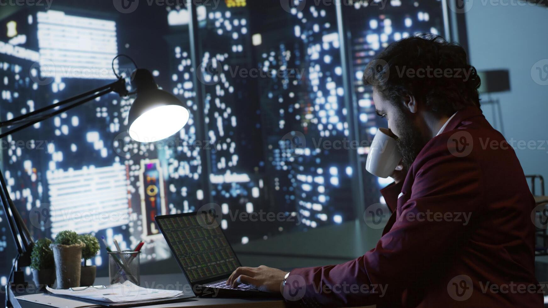 Auditor reviewing company financial statements and transactions to confirm their accuracy, working after hours in high end office to sort funds problems for CEO. Expert makes trades on stock market. photo