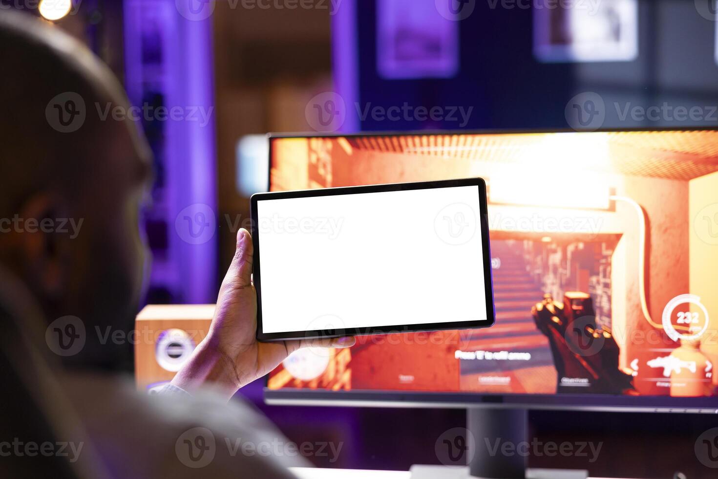 Player looking at isolated screen tablet, taking break from playing singleplayer videogame on gaming computer, close up. Man in home using mockup portable device while enjoying game photo