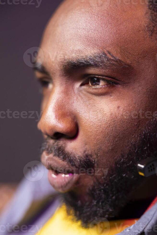 African american streamer competing in intense online multiplayer videogame, streaming live at home, close up shot. Man playing on gaming PC, using headphones to discuss with viewers photo