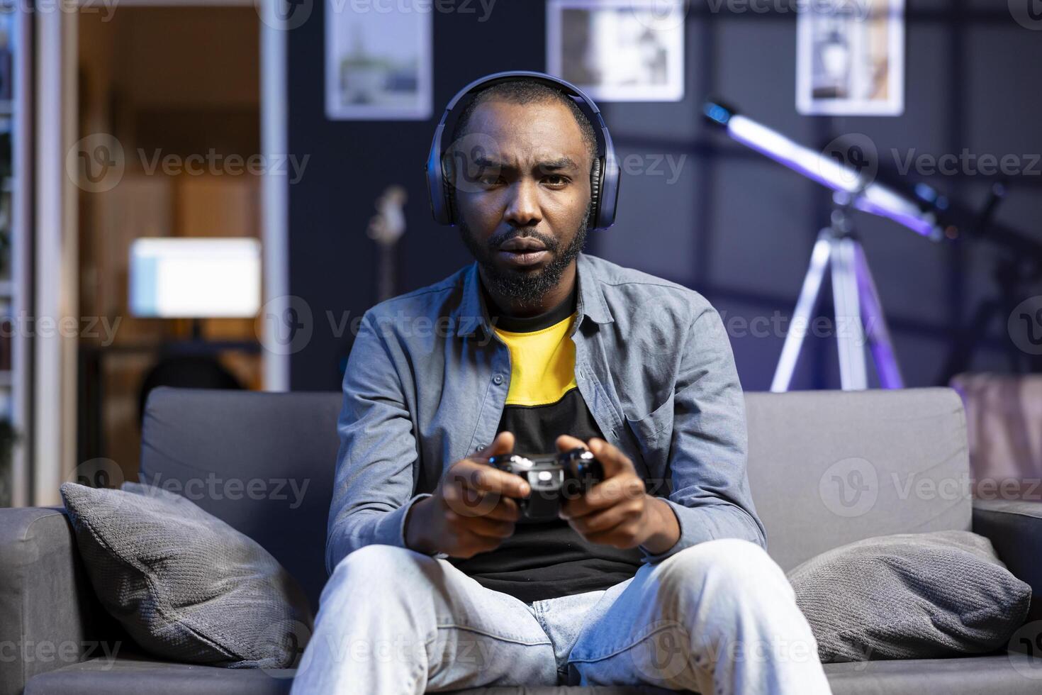 Portrait of irritated gamer upset after losing in online multiplayer videogame played using controller. Man frustrated after seeing game over message while playing on console photo