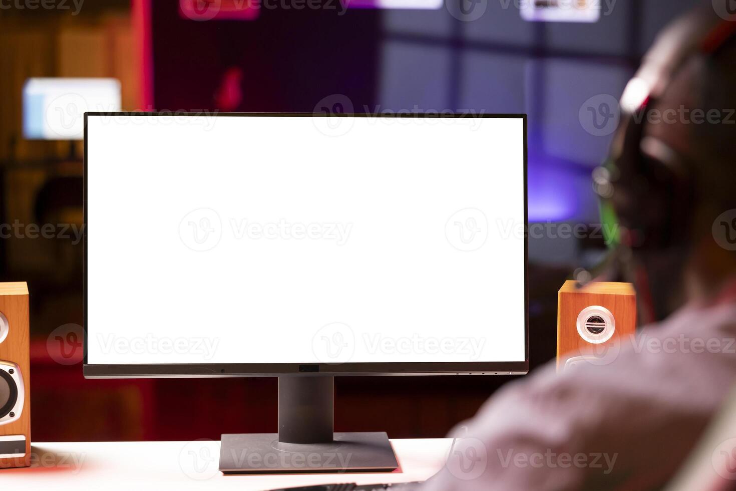 Professional streamer looking at isolated screen monitor, competing in online videogame, streaming live at home. Mockup display used by man playing on PC, using headphones to talk, close up photo