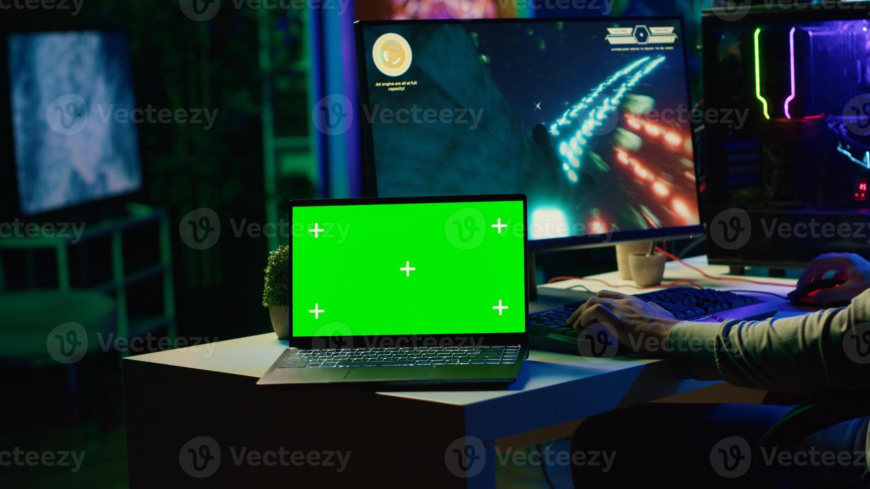 Green screen laptop next to man having fun by using gaming keyboard to fly spaceship in SF videogame. Mockup notebook and gamer using powerful PC and computer peripherals to play game photo