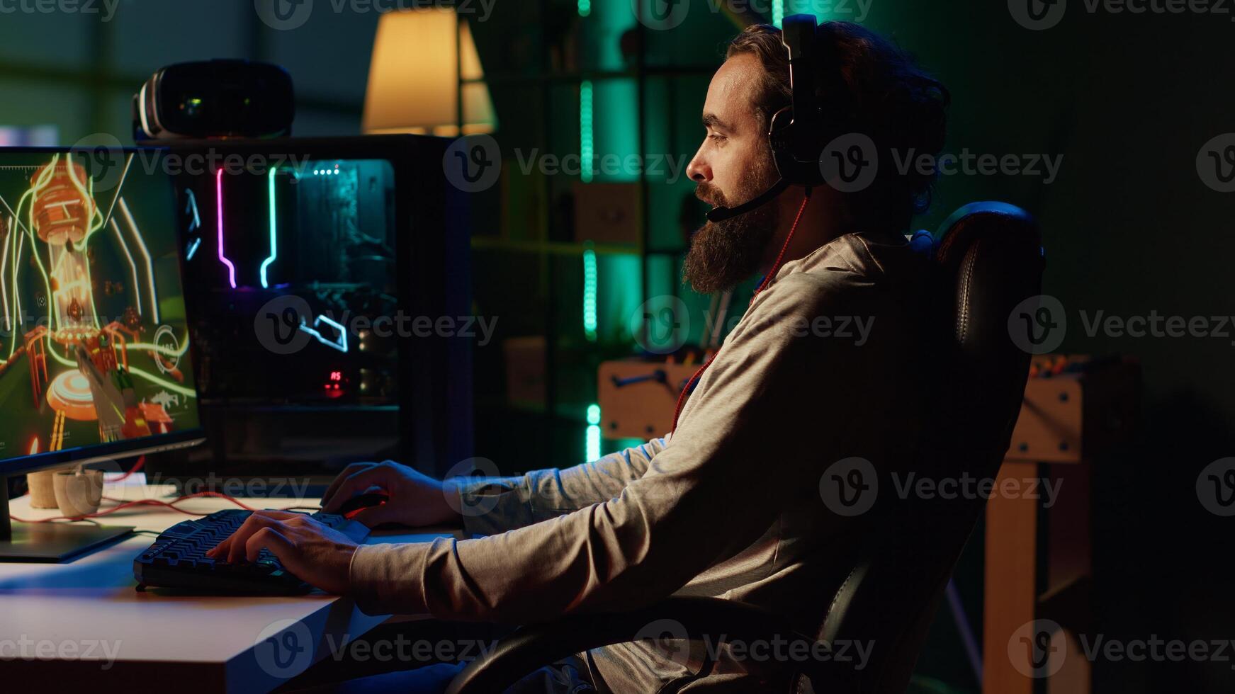 Man plays first person shooter videogame with internet teammates, discussing strategy to defeat flying robots. Gamer talking with friends in competitive PvP fps multiplayer game photo