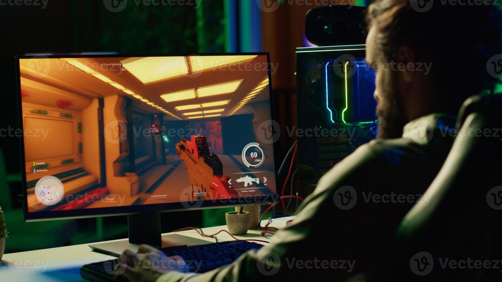 Man in dark living room playing engaging video games on gaming PC at computer desk, chilling after work. Gamer contending against foes in online multiplayer shooter, shooting them with lasers photo