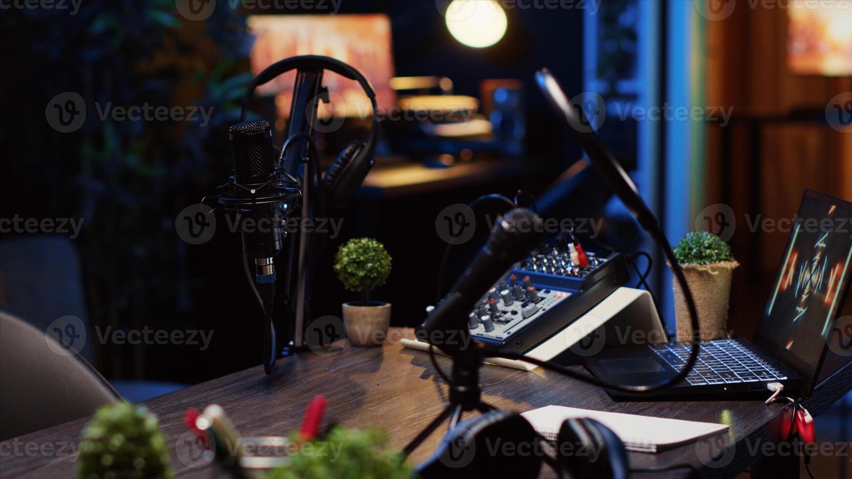 Panning shot of desk in home production studio with podcast equipment technology recording sound and 3D animations running on laptop screen. Professional broadcasting space in apartment photo