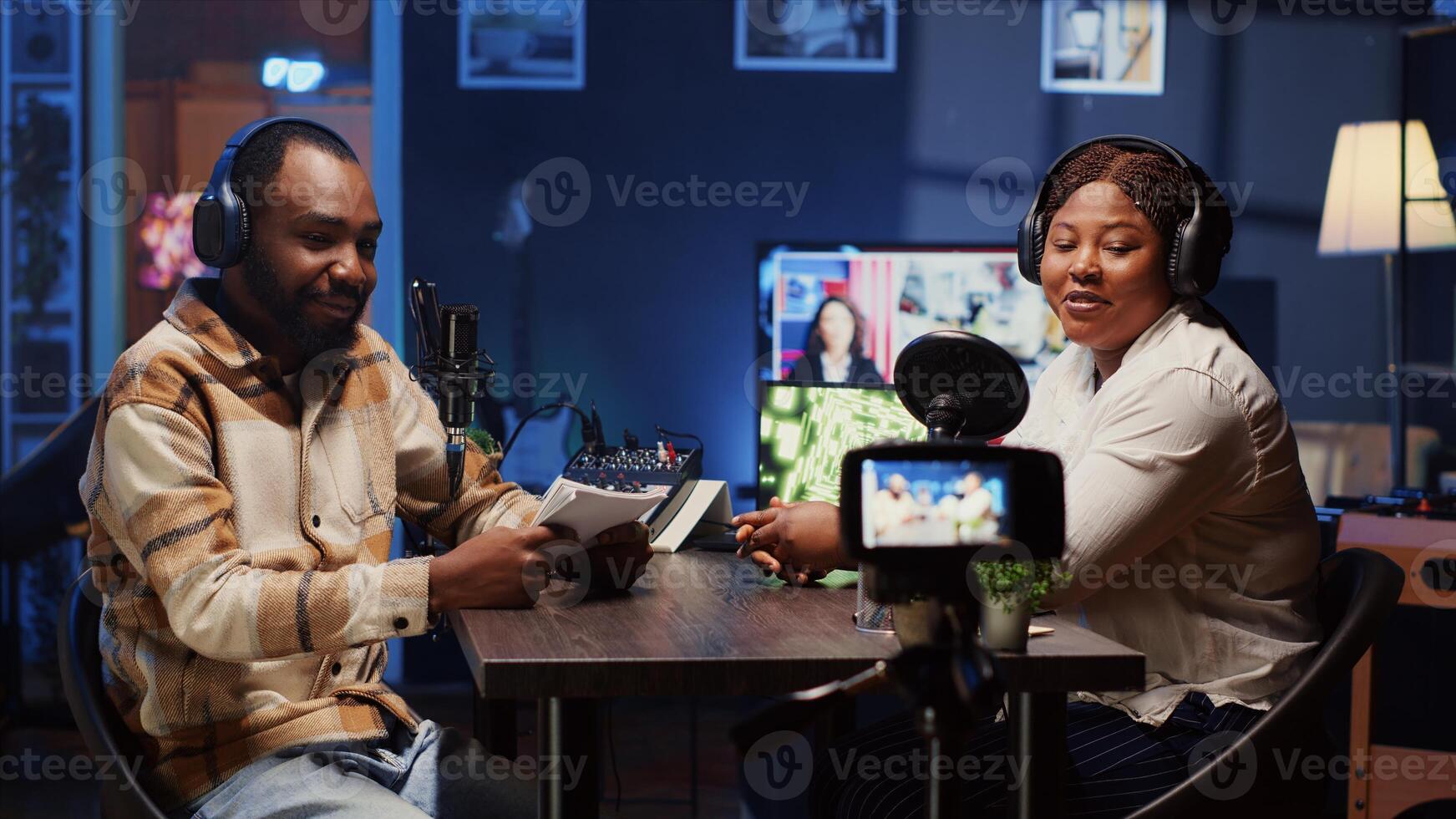 Man recording podcast with woman, using high quality camera and professional microphones to interview guest, ensuring spotless video and sound quality for viewers watching at home photo